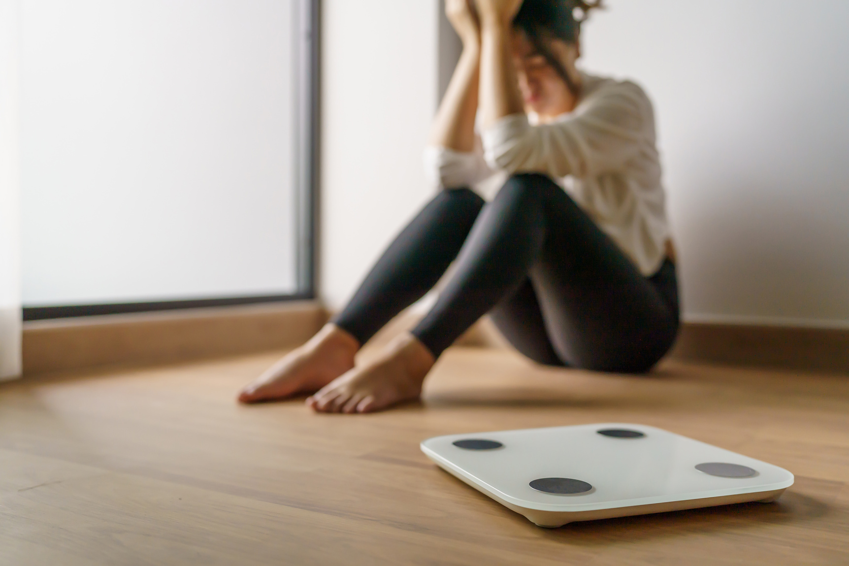 Upset Woman with Weighing Scale in a Room